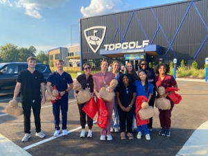 Volunteers stand in front of Top Golf, where they held a CPR training event